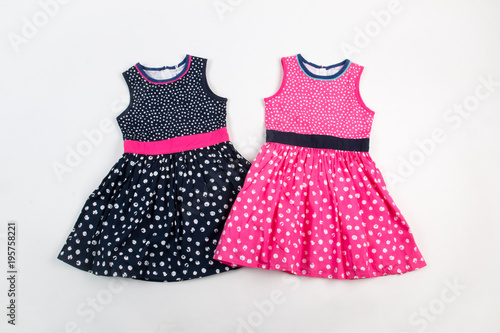 Elegant light children summer dresses. Pink and black on white dots