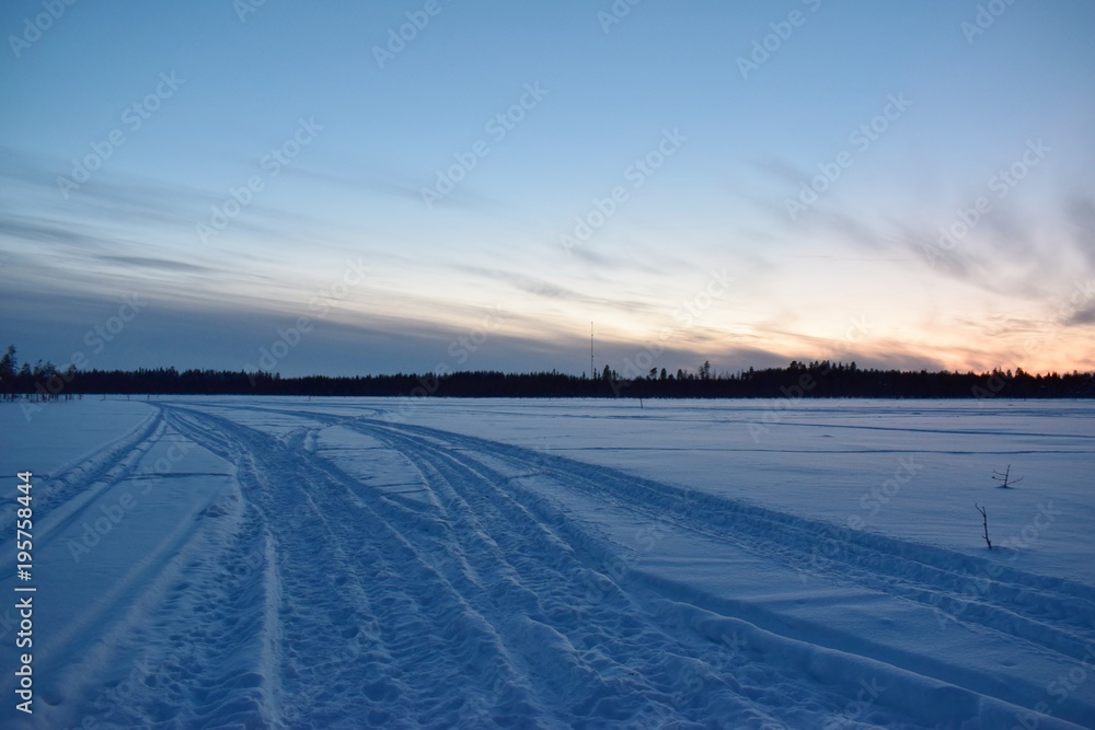 traces of snowmobiles during sunset in Finnish Lapland 2