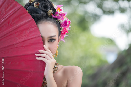 Beautiful Thai girl in traditional dress costume red umbrella, Thai Woman in Traditional Costume of Thailand.