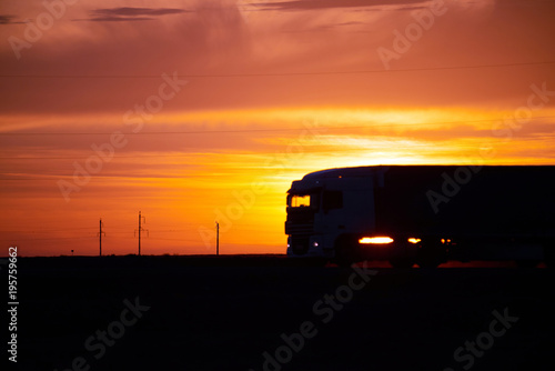 Silhouette of a moving truck at sunset. A truck is a motor vehicle designed to transport cargo. Trucks vary greatly in size, power, and configuration.