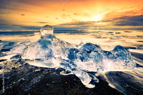 Drifting icebergs on Diamond beach, at sunset, in Jokulsarlon, Iceland.
