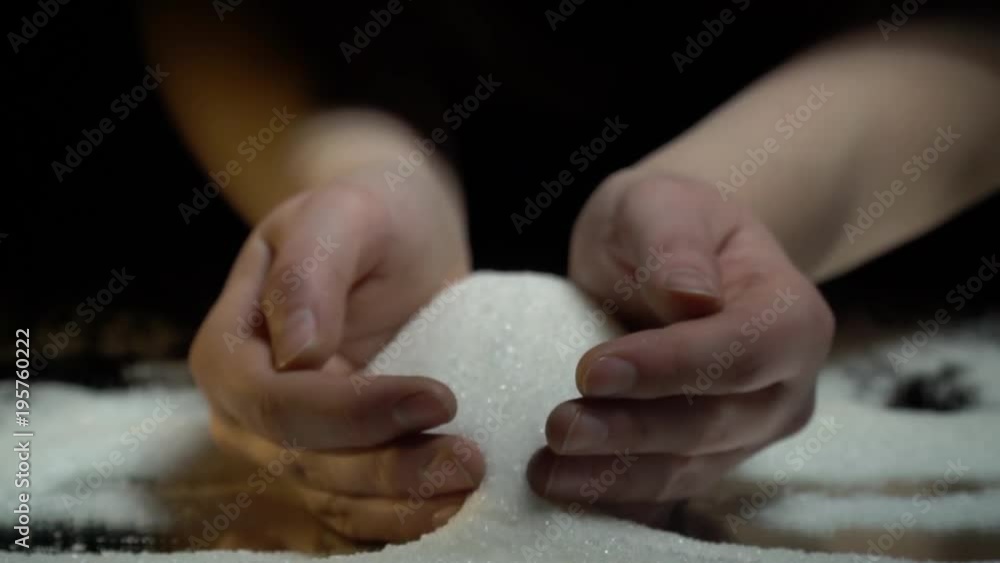 Female hands pour sugar on a black background, slow motion Female hands pour sugar on a black background, slow motion