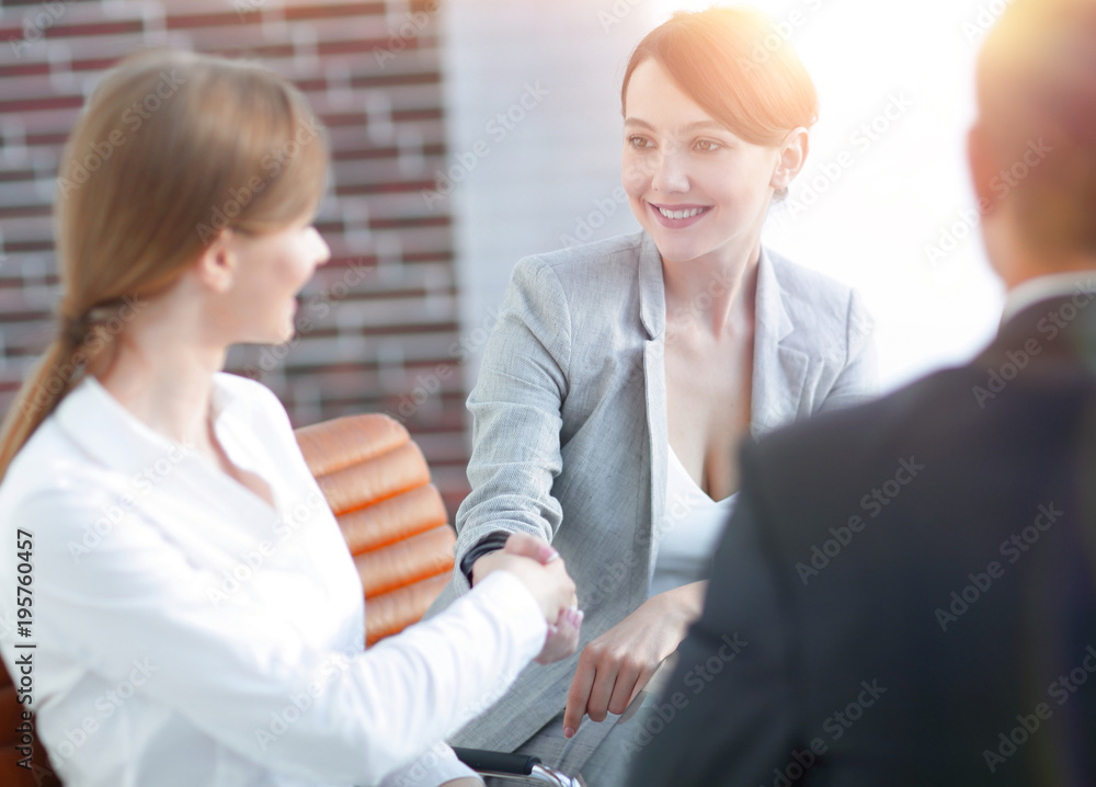 Fototapeta premium handshake of a Manager, and a client sitting behind a Desk