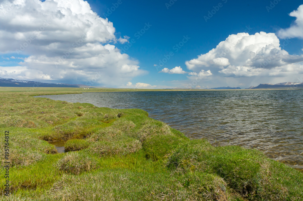 A stunning mountain lake Son-Kul, with amazing clouds and blue skies