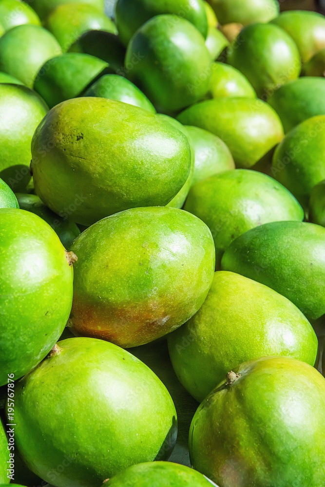 Bunch Pile of Ripe Vibrant Green Mangoes at Farmers Market in Asia. Bright Sunlight. Travel Lifestyle Image. Vitamins Superfoods Healthy Diet Concept. Bunch Pile of Ripe Vibrant Green Mangoes at Farmers Market in Asia. Bright Sunlight. Travel Lifestyle Image. Vitamins Superfoods Healthy Diet Concept.