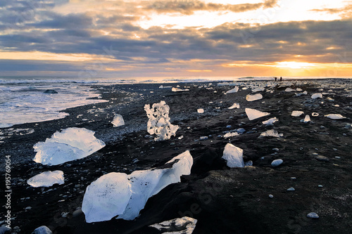 Ice blocks on black volcanic sand, at sunset, on Diamond beach, in Jokulsarlon, Iceland. © mandritoiu