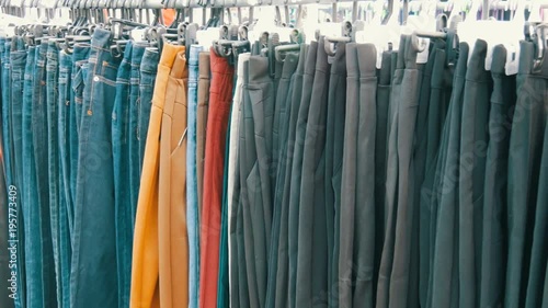 Wallpaper Mural Pants hang on hanger, women look at clothes and choose. Flea market, clothes sold on the market Torontodigital.ca