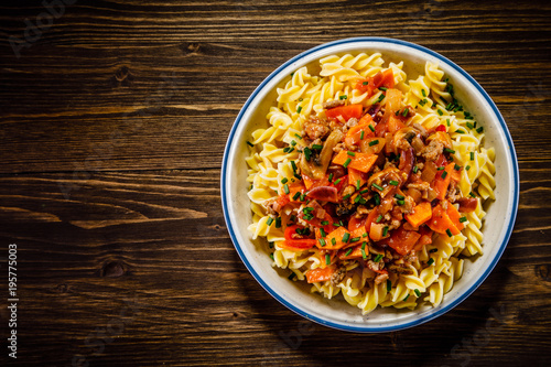 Pasta with tomato sauce and vegtables on wooden table  photo