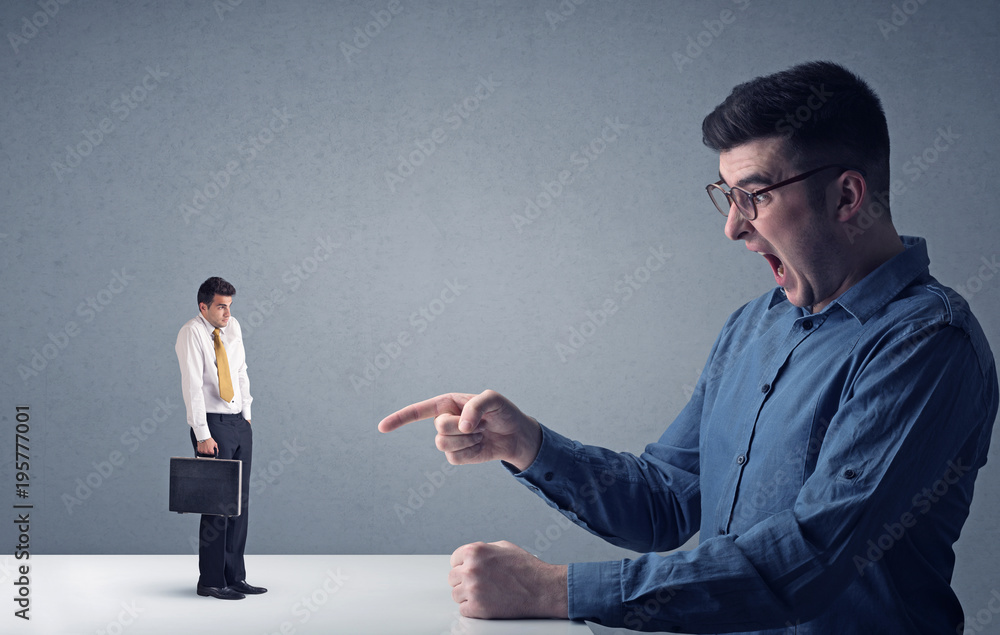 Young businessman fighting with miniature businessman Young businessman fighting with miniature businessman