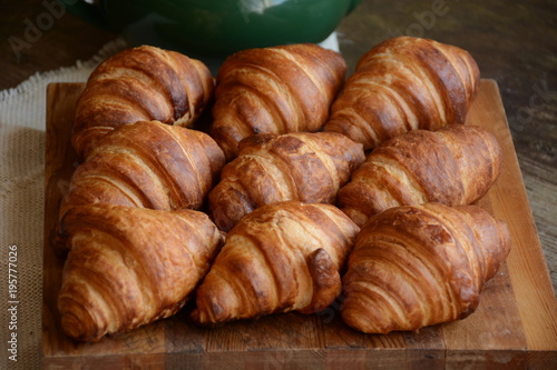 freshly baked croissants on wooden cutting board. Breakfast with croissants. 