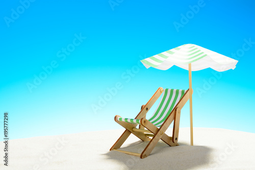 A chaise longue under an umbrella on the sandy beach  sky with copy space