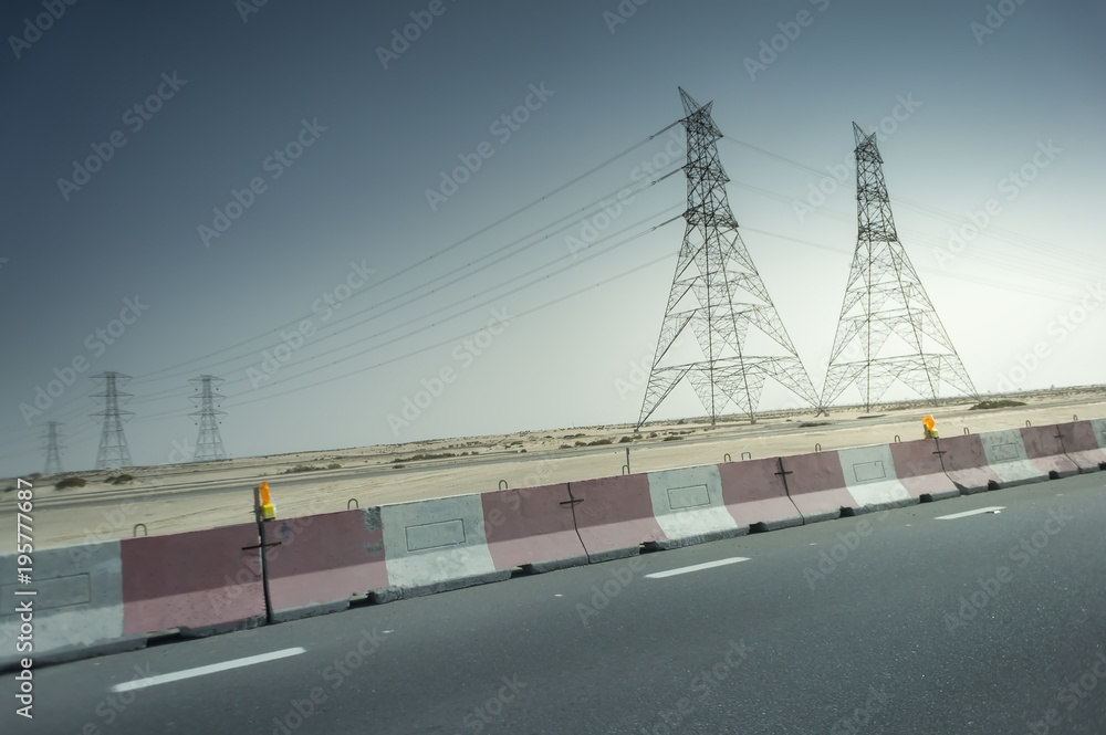 highway with concrete barriers and transmission tower