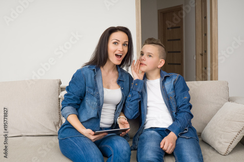 Portrait of mother and her son on sofa at home