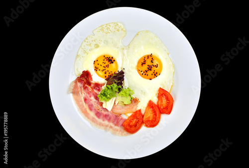 Isolated scrambled eggs with a bacon and tomatoes on a white plate.