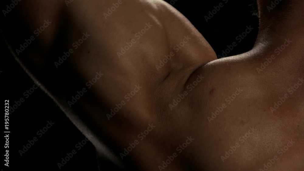 Close up man lifting heavy dumbbell. Detail of mans biceps flexing on black background. Tips for bigger and strong arms. Close up man lifting heavy dumbbell. Detail of mans biceps flexing on black background. Tips for bigger and strong arms.