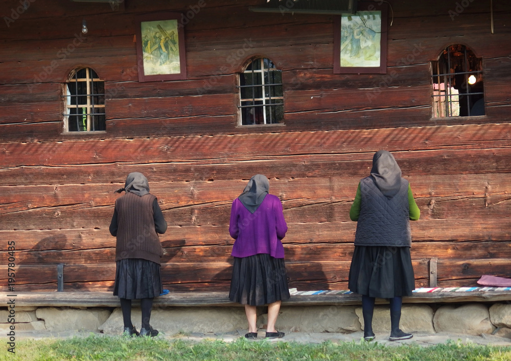 Rumunia, Maramuresz - stare kobiety modlą się na cmentarzu przy cerkwi w Leud - obrazy, fototapety, plakaty 