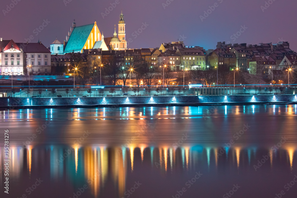 Old Town with reflection in the Vistula River during evening blue hour, Warsaw, Poland.