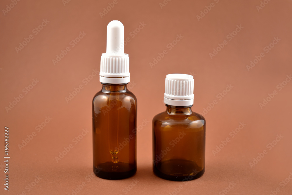 Two brown vials stock images. Empty cosmetic bottle. Vials on a brown background. Brown glass containers. Brown chemical glass Two brown vials stock images. Empty cosmetic bottle. Vials on a brown background. Brown glass containers. Brown chemical glass