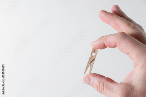 small wooden clothespins lie on the palm of the hand on a white background photo