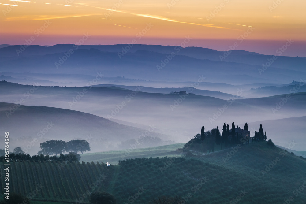 Stunning foggy fields at dawn in Tuscany, Italy