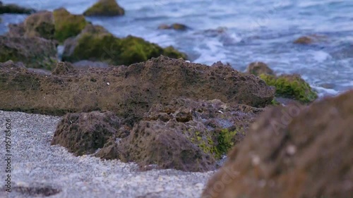 Small waves gently hitting the rocky beach 