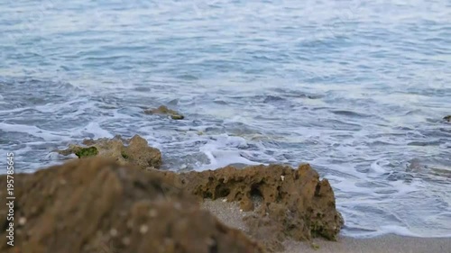 Small waves gently hitting the rocky beach 