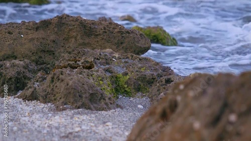 Small waves gently hitting the rocky beach 