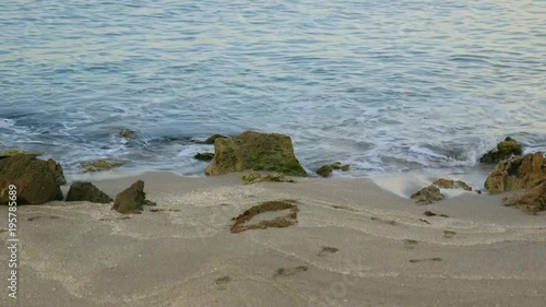 Small waves gently hitting the rocky beach 
