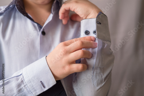 a young man zip up a light shirt and sleeves at the shirt