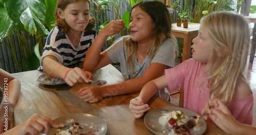 Happy young pre teenage girls sharing delicious desserts together