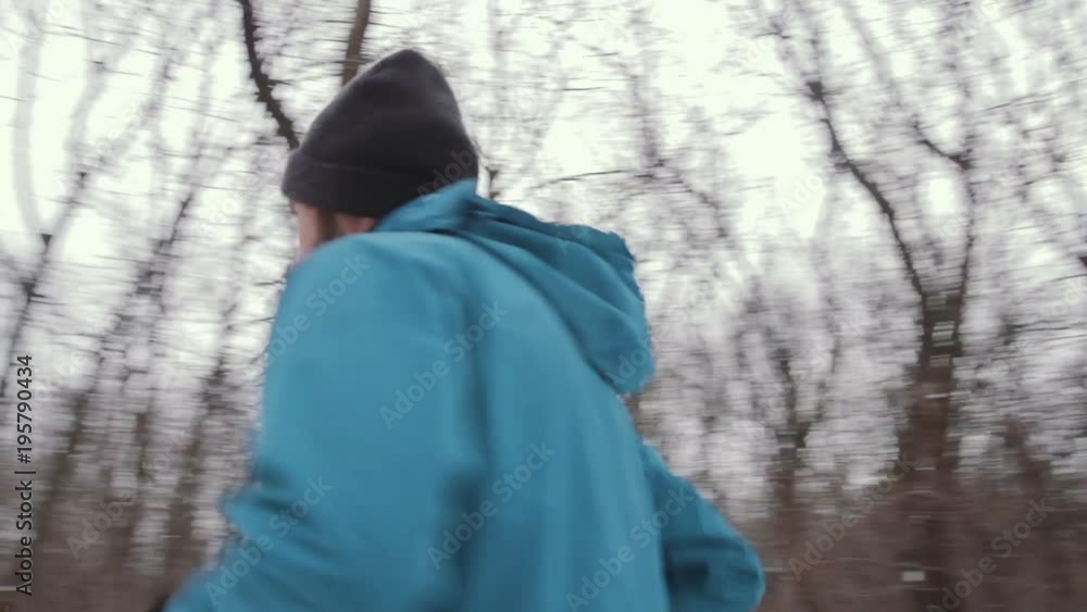 male athlete training in winter forest, trail runner, fit man do exercises in cold weather male athlete training in winter forest, trail runner, fit man do exercises in cold weather
