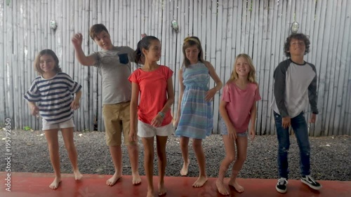 Diverse group of young pre teenage children jumping up in a line