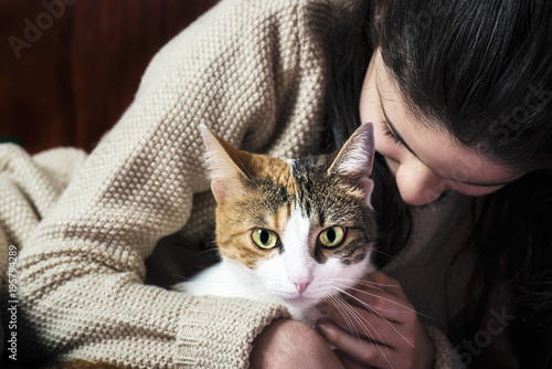 Girl caressing a cute cat photo