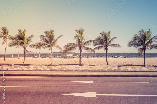Beach with palms behind the asphalt road. Ipanema Beach, Rio de Janeiro, Brazil. Light effect