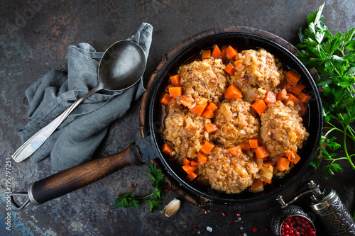 Veal meatballs stewed in frying pan with carrot in vegetable sauce. Delicious meat dish