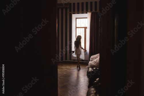 silhouette of a beautiful young girl who goes to the window