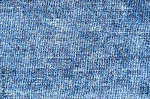Jeans in acid wash blue. Denim background, texture, close up. Faded wash photo