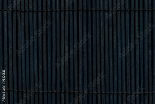 Black Bamboo Mat on Dark Background Tied Up With the Rope