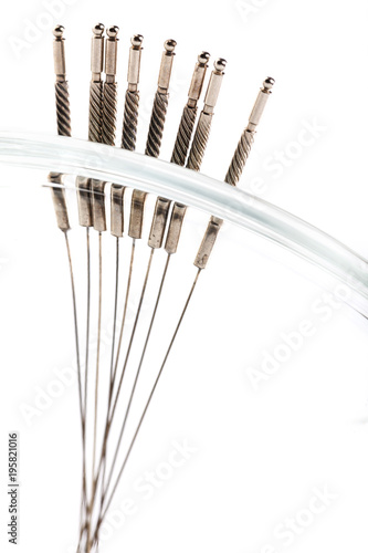 Silver needles for traditional Chinese acupuncture medicine. White background. Selective focus. There is room for your text or sign.