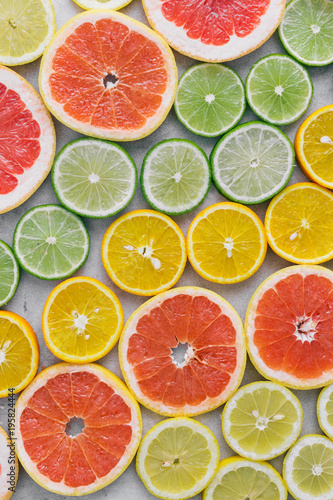 Top view of sliced citrus fruit on light background. Flat lay. Summer background