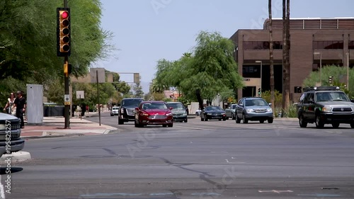  Street traffic in Tucson. Drivers commuting and pedestrians walking in a busy intersection close to the Tucson's downtown.