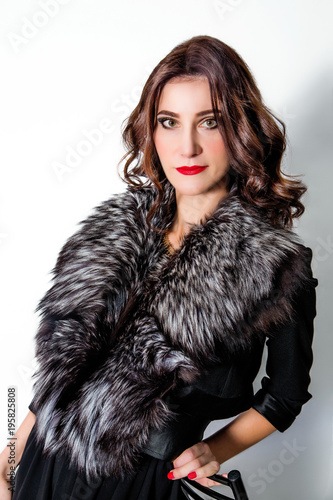 beautiful chic woman in dress and fur collar on white background