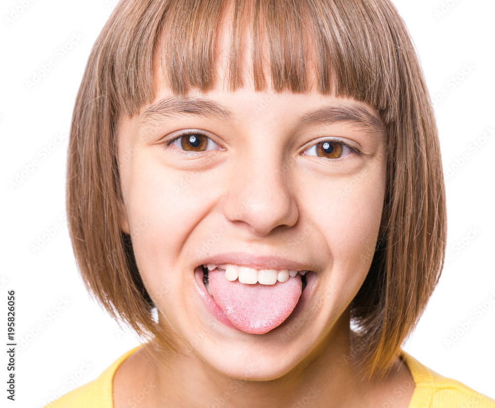 Obraz premium Nice girl showing her tongue. Child puts out tongue - close up.