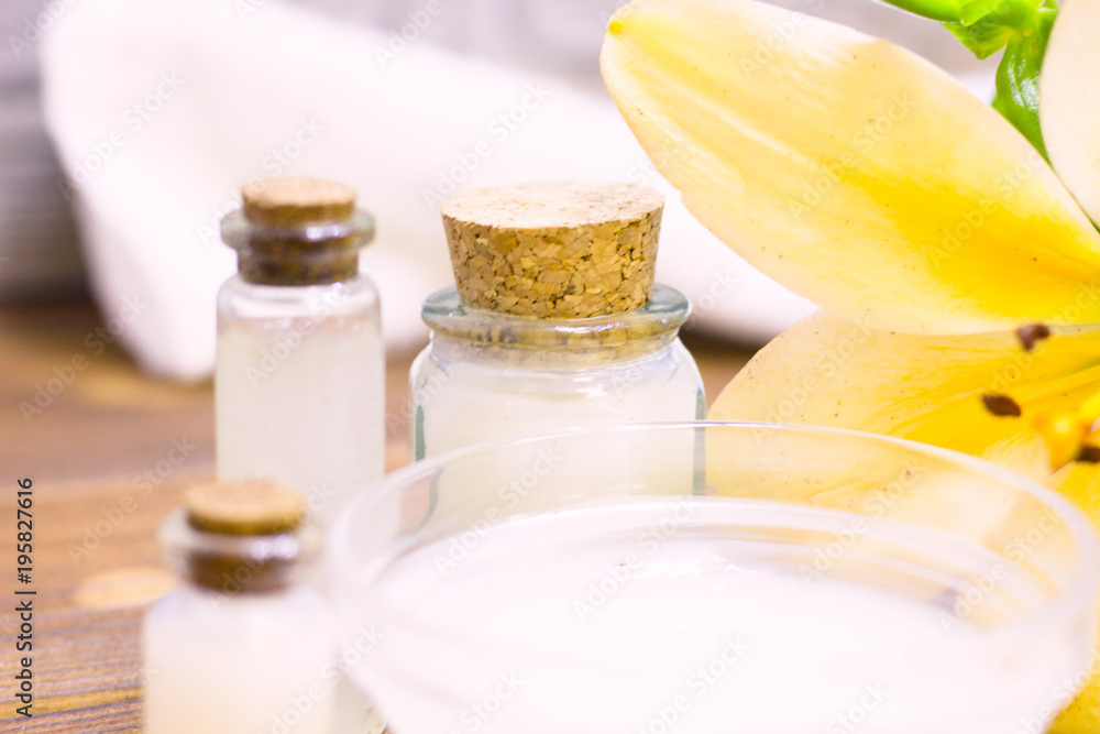 Natural herbal skin care products, top view ingredients coconut, lily flower, essence oil on table concept of the best all natural face moisturizer. Facial treatment preparation background Natural herbal skin care products, top view ingredients coconut, lily flower, essence oil on table concept of the best all natural face moisturizer. Facial treatment preparation background
