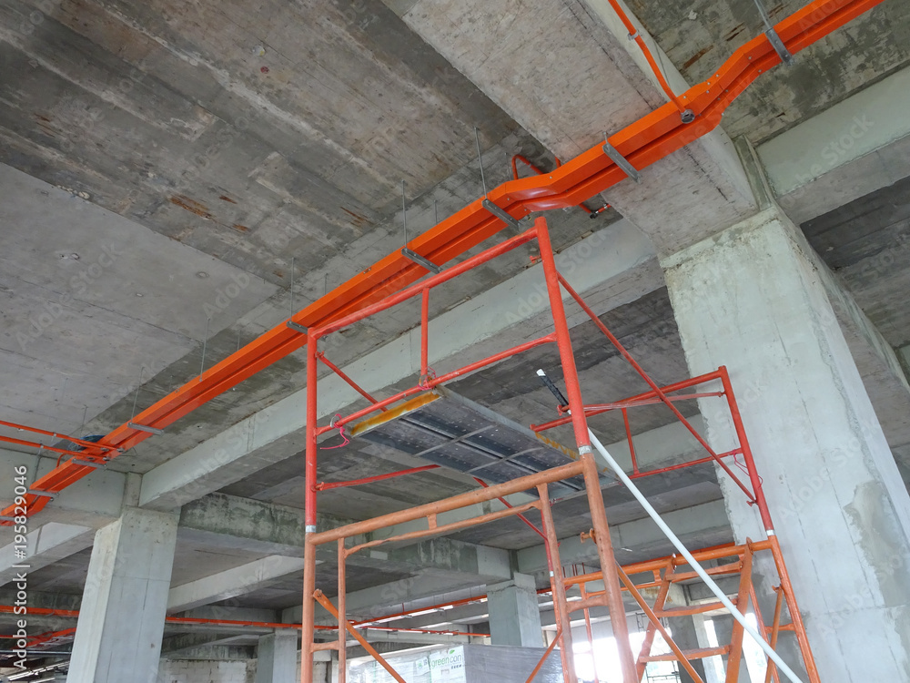 Construction workers installing electrical conduit and cable tray made