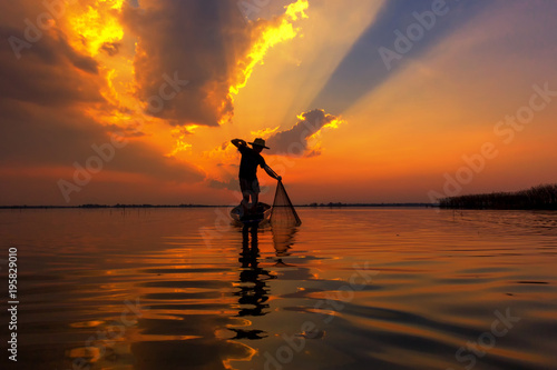 Silhouette fisherman with sunset,Take photo fisherman young woman with sunset © Krizde