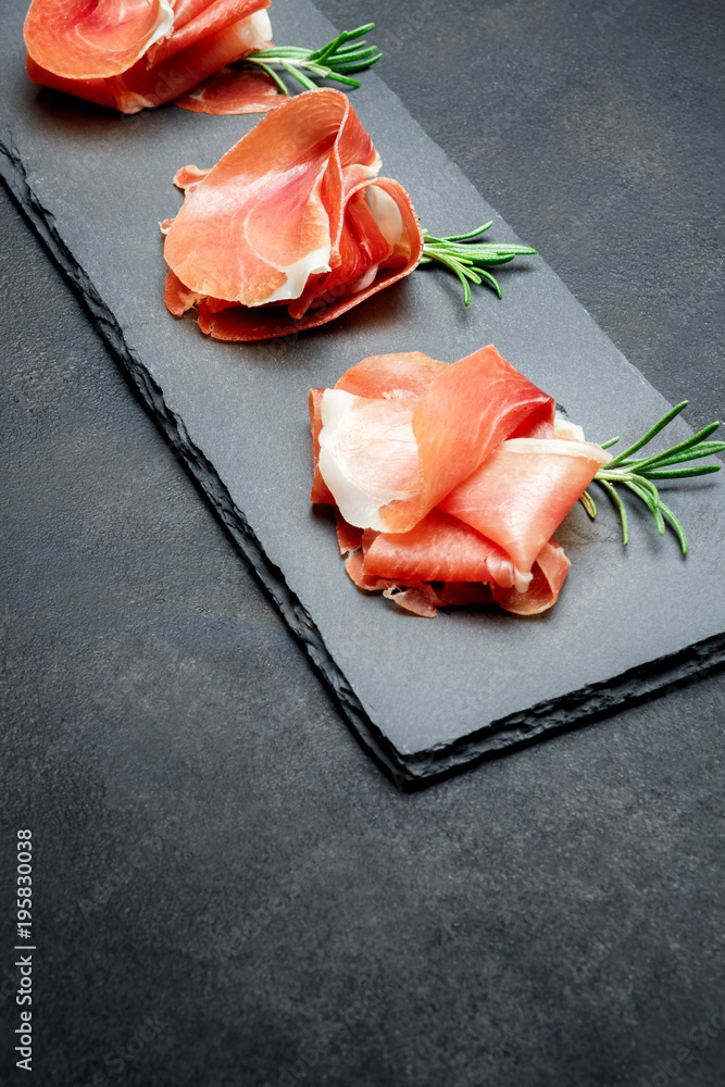 Italian prosciutto crudo or spanish jamon. Raw ham on stone cutting board