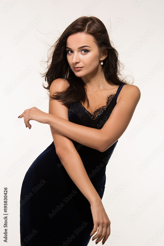 Fototapeta premium Portrait of a beautiful young girl with dark long hair and professional make-up on a white background.