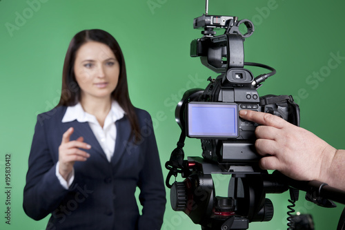 Record interview on professional digital equipment. Television announcer isolated on green background in blur