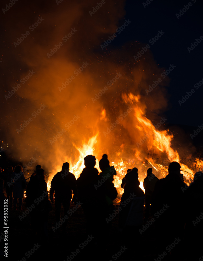silhouettes of people in frontof big fire